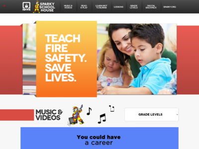 Screenshot of the Sparky School House website. A banner reads "Teach Fire Safety. Save Lives." with a teacher aiding young students. Below, a section titled "Music & Videos" features a cartoon mascot, and there's a prompt saying, "You could have a career." Grades levels are selectable.