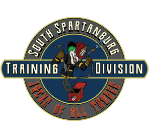 Logo for South Spartanburg Training Division featuring a firefighter character wearing a helmet and holding a hammer and crowbar. The text reads "Jacks of All Trades" surrounding the circular emblem.